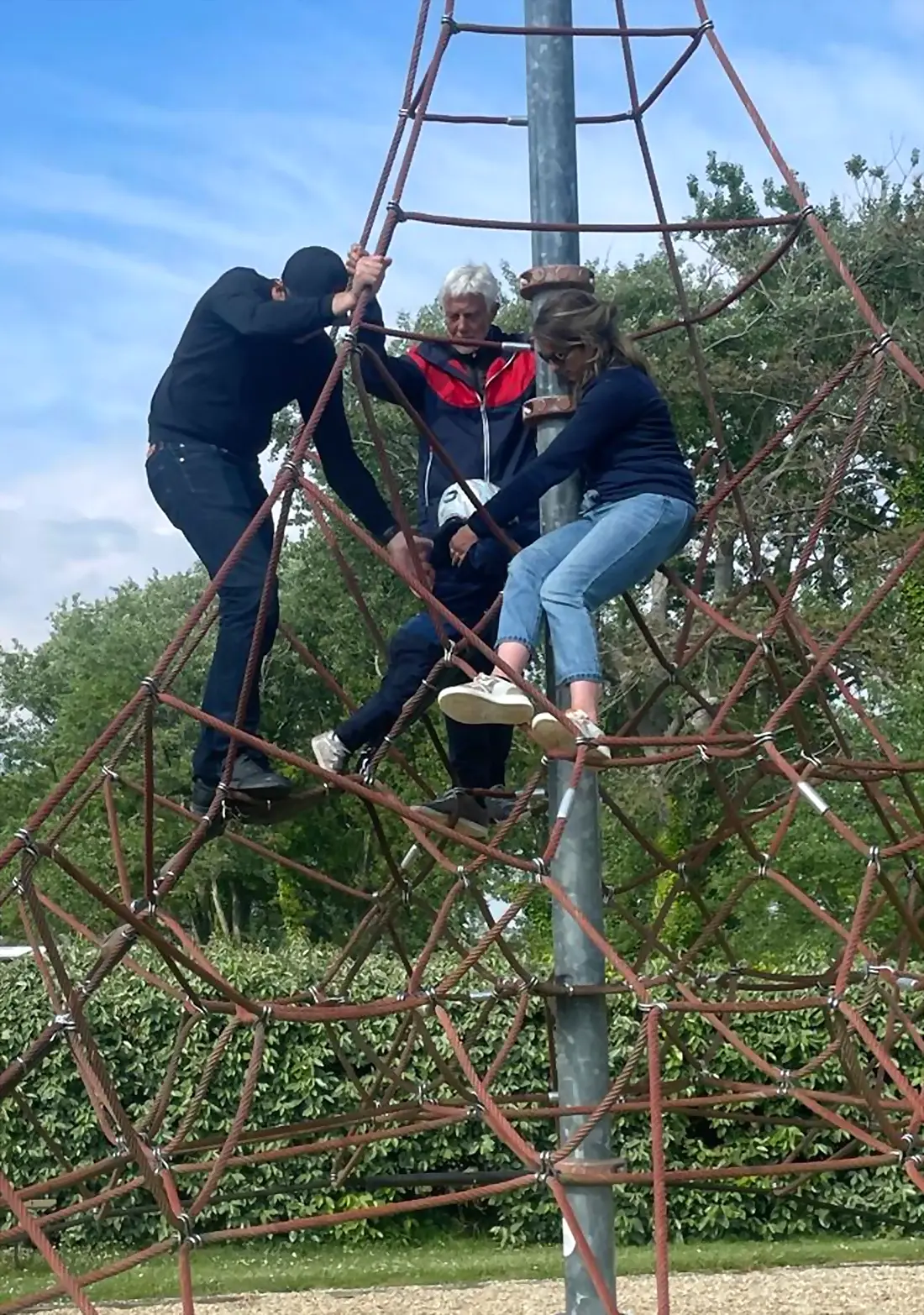 Plusieurs générations grimpent ensemble sur une structure de cordes